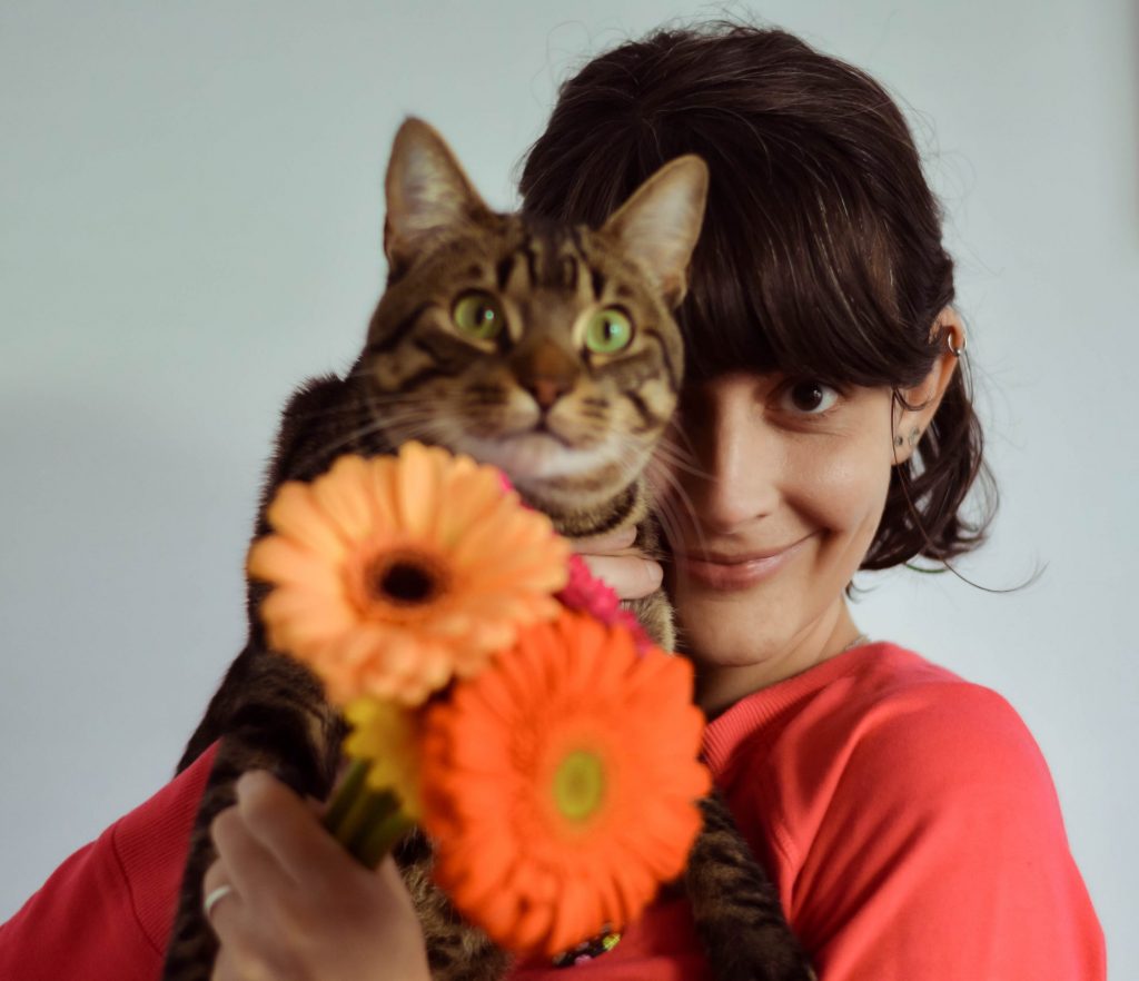 Foto de Laura, con un gato y flores